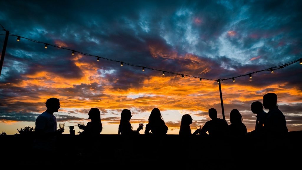 silhouettes of people on the rooftop bar at the Tudor Hotel Tamworth with a beautiful sunset in the background