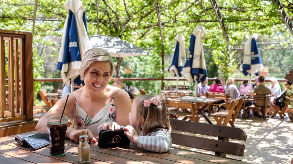 Mother and daughter sitting at a table in the beer garden of the Peel Inn, Nundle